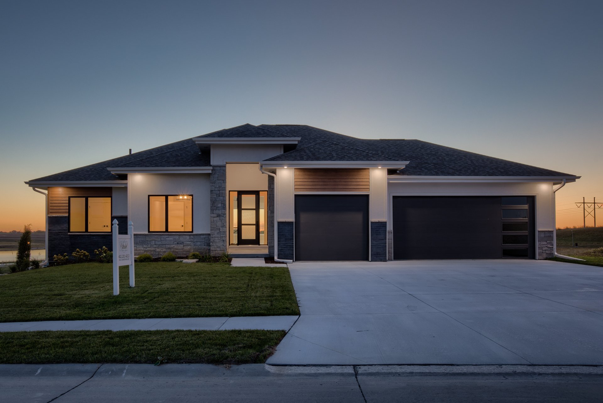 front curb view of a ranch style home at dusk designed by citadel signature homes in omaha, nebraska